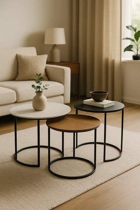 Drie bijzettafels in verschillende hoogtes en materialen in een moderne woonkamer.