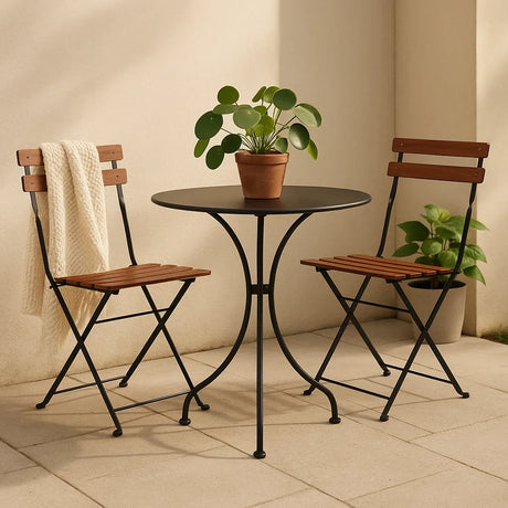 Franse bistroset met ronde tafel en houten stoelen op een terras met planten.
