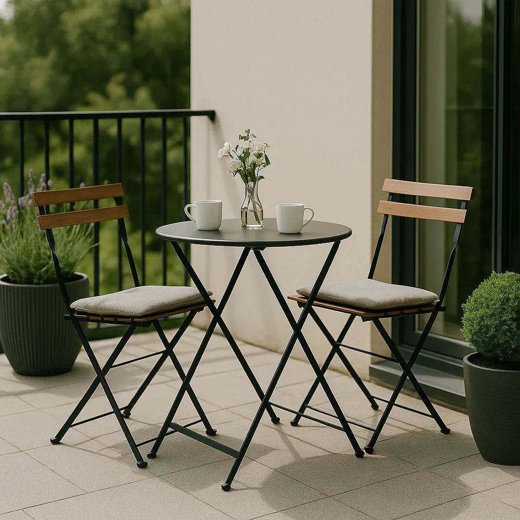 Bistroset op balkon met zwarte metalen stoelen en ronde tafel met houten accenten.