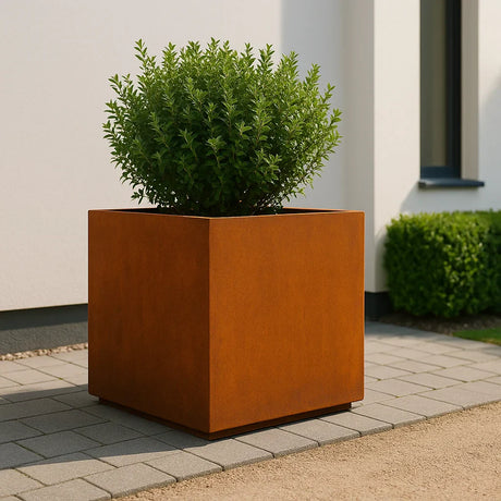 Cortenstaal plantenbak met groene struik op een modern terras