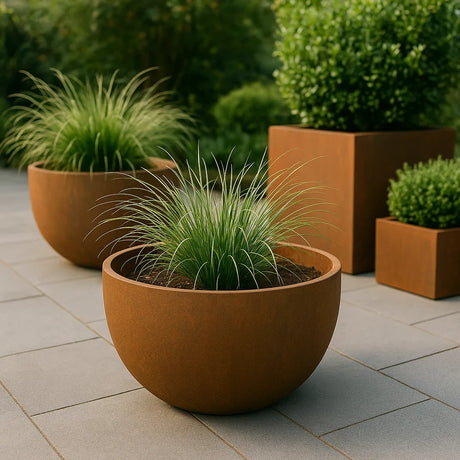 Cortenstaal plantenbakken rond en vierkant op terras.