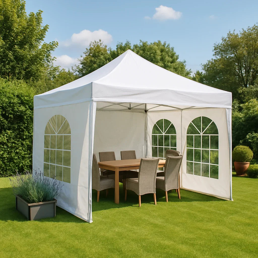 Witte partytent in tuin met houten tafel en wickerstoelen