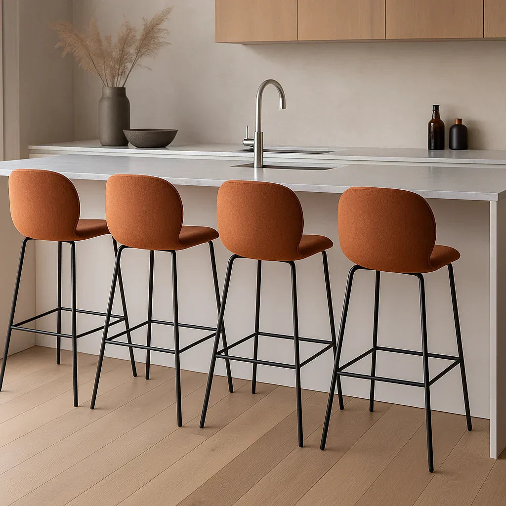 Moderne keuken met design barkrukken langs een kookeiland, verlicht door hanglampen.